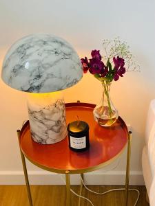 马恩河畔莱佩尔勒Luxury flat near Paris & Disney的一张桌子,上面有台灯和花瓶