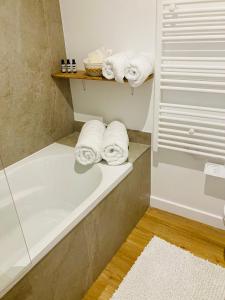 马恩河畔莱佩尔勒Luxury flat near Paris & Disney的浴室配有浴缸,架子上配有毛巾
