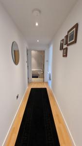 利兹Excellent Leeds City Centre 1 Bedroom Apartment的一条带白色墙壁和黑色地毯的走廊