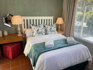 赫曼努斯Joy@Grotto Beach, Hermanus的一间卧室配有一张大床和毛巾
