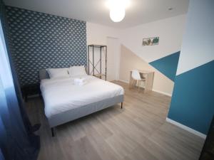 鲁贝NG SuiteHome l Lille l Roubaix Gare l Cassel - Netflix - Wifi的卧室配有白色的床和椅子