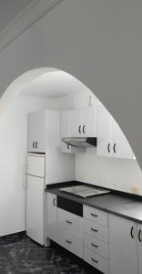 阿里纳加Sun and Sea House 3 Rooms & Wifi的厨房配有白色橱柜和炉灶烤箱。