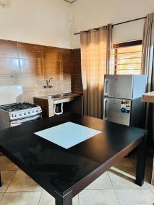 伊尼扬巴内Casa para Férias的厨房配有黑桌和冰箱。
