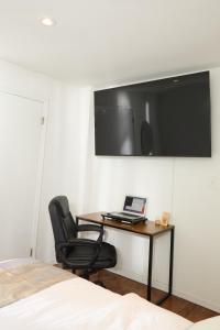 纽约American Dream Guest House的一间卧室配有一张桌子、一台笔记本电脑和一把椅子