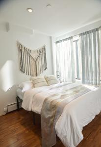 纽约American Dream Guest House的一间白色卧室,配有两张床和窗户