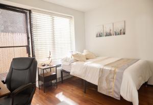 纽约American Dream Guest House的卧室配有床、椅子和窗户。