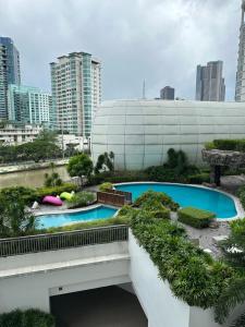 马尼拉RJMR Acqua private residence的城市中2个泳池的景色,拥有高大的建筑