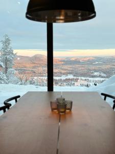 耶尔夫瑟Toppvillan - Ski In - Ski Out - 200 m till toppen och cykelleder的一张桌子和一盏灯,享有雪景