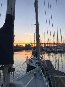 里斯本Cozy Lisbon Marina Sleepaboard - Sail Away的日落时停靠在港口的帆船