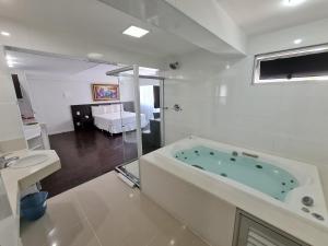 贝洛奥里藏特Hotel San Diego Pampulha - Flats Particular的白色的浴室设有浴缸和水槽。