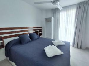 科隆Catalina Hotel的一间卧室配有蓝色大床和蓝色枕头