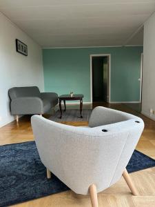 斯德哥尔摩Home Stays-Private Rooms in a Villa Near City for families/Individuals的客厅配有沙发和椅子