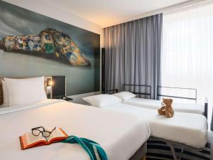 奥利巴黎科尔奥利机场诺富特酒店的两间位于酒店客房的床,上面有泰迪熊