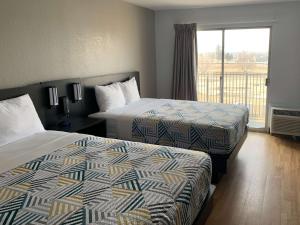 林垦Motel 6-Lincoln, NE - Airport的酒店客房设有两张床和一个阳台。
