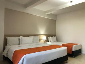 麦德林努提巴拉酒店的配有两张床的酒店客房中的两张床