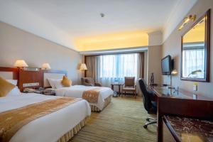 福州福建阳光假日大酒店的酒店客房配有两张床和一张书桌