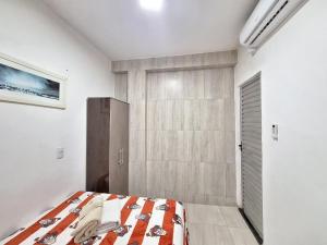 萨尔瓦多Mar.5: Compact close to Stella Maris beach and Airport的一间卧室配有一张床和一个步入式衣柜