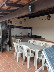 圣佩德罗-达阿尔德亚Região dos Lagos - casa para temporada的一间带桌子和白色椅子的用餐室