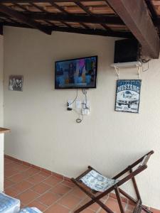 圣佩德罗-达阿尔德亚Região dos Lagos - casa para temporada的墙上的椅子和电视