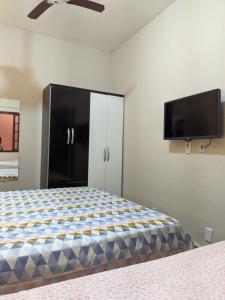 圣佩德罗-达阿尔德亚Região dos Lagos - casa para temporada的一间卧室配有一张床和一台平面电视