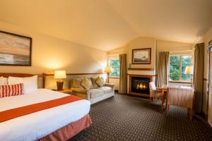 卡农海滩坎农比奇酒店的酒店客房配有一张床和一个壁炉。