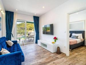 波梅纳Seaside apartments with a swimming pool Pomena, Mljet - 22317的一间卧室配有一张特大号床和一张蓝色的沙发