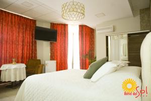 塔里哈Hotel del Sol的卧室配有一张白色的大床和一张桌子