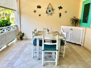 拉斯特拉纳斯La Dolce Vita Beachfront Apt 2的一间配备有白色桌椅的用餐室
