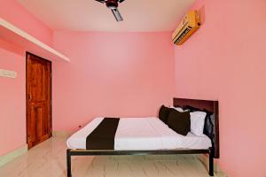 克塔克OYO MAA BHUASUNI RESIDENCY的卧室配有一张粉红色墙壁上的床铺
