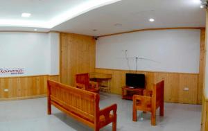 碧瑶Koinonia Retreat CenteR的一间带长椅、电视和桌子的房间