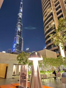 迪拜Emaar Residences Fashion Avenue - Formerly Address Dubai Mall的坐在建筑物前桌边的灯