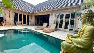 努沙杜瓦Kubu Dimel Suites and Villas Resort的游泳池旁的佛陀雕像