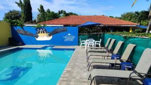 普拉亚科罗纳多Las Catalinas Coronado的一个带桌椅的游泳池和一个围栏