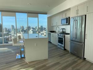 圣地亚哥Massive Penthouse Overlooking All of San Diego的一间厨房,配有白色的橱柜,享有城市美景