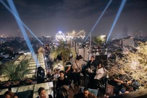 河内La Mejor Hotel & Sky Bar的一群人晚上坐在屋顶上