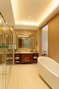 Lancang澜沧华隆大酒店的一间带大浴缸和镜子的浴室