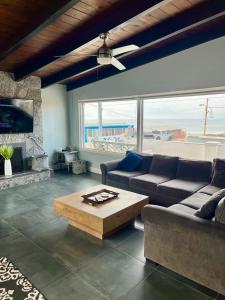 罗萨里托Rosarito Beach House Sleeps 14 & Steps to Sandy Beach Mins to Downtown的带沙发和咖啡桌的客厅