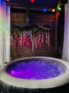 圣安德烈ô Bois Dormant, Bungalow privé的紫色水和灯光按摩浴缸