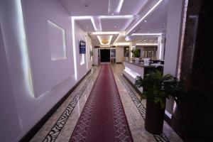 泰布克Hotel and Apartments Al Raqi Mall Artiaad的楼房里铺着红地毯的走廊