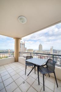 悉尼Oaks Sydney Castlereagh Suites的设有一个配有桌椅并享有美景的阳台。