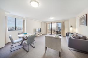 悉尼Oaks Sydney Castlereagh Suites的客厅配有沙发和桌子