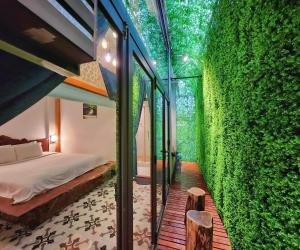 顺化Victory Hotel的一间卧室设有一张带床铺的绿色墙壁