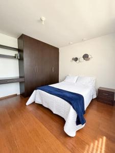 伊瓦拉Home Ibarra Parque Ciudad Blanca的一间卧室配有一张大白色床和蓝色毯子