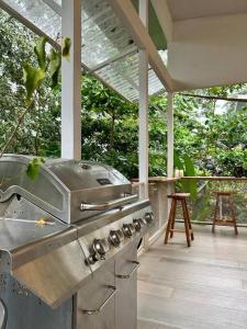 LagunillasJaco, Peace Home around nature的露台上的户外厨房配有烧烤架