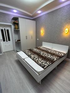 BagyshGuest House Alym-Ata的卧室配有一张大床,位于带墙壁的房间