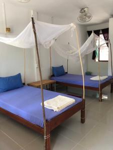 高龙撒冷岛Mangrove Beach Bungalows的带三张床和天篷的房间