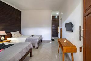 蓝梦岛Widia Homestay Nusa Lembongan的酒店客房设有两张床和一张桌子。