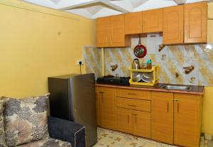 KeruguyaQwetu Homes的一间带木制橱柜和冰箱的小厨房