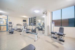 悉尼Oaks Sydney Castlereagh Suites的健身房设有数台跑步机和有氧运动器材