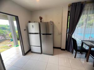 卡伦海滩Blue Sky Villa的厨房配有冰箱、桌子和窗户。